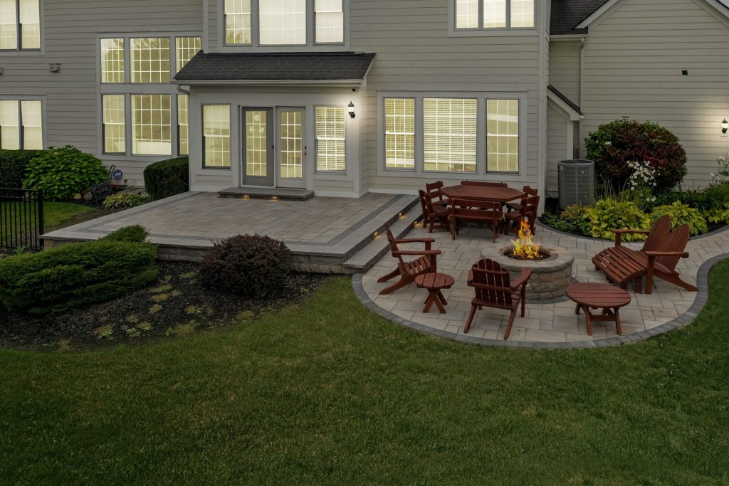 default Rear of home with a deck and steps, a custom patio with pavers, stamped concrete, and a fire pit